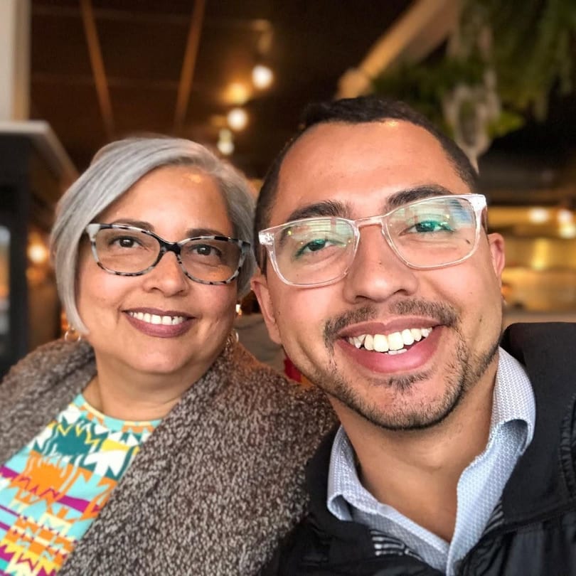 Two smiling people, a woman with gray hair and a man with a beard, posing for a selfie.