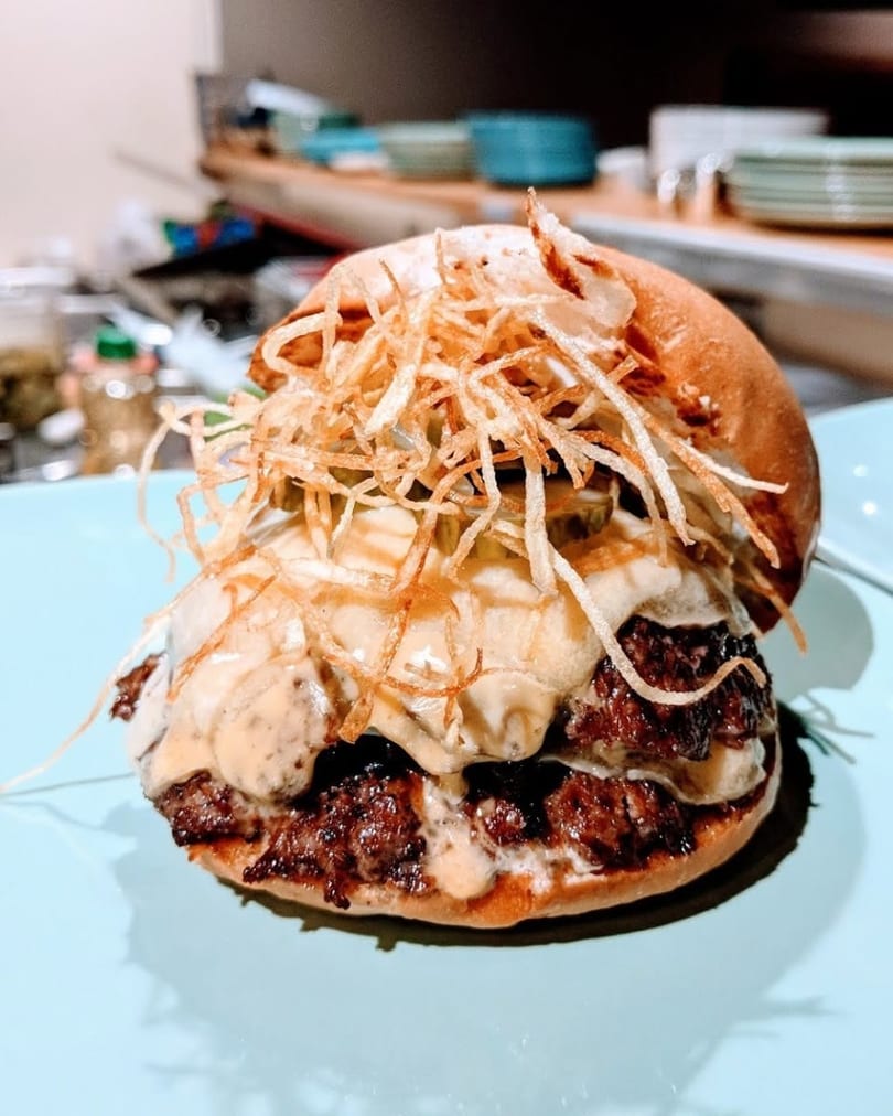 A double smash burger with melted cheese, pickles, special sauce, and crispy fried onions.